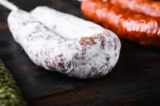 Spanish dry fuet sausages on wooden surface.