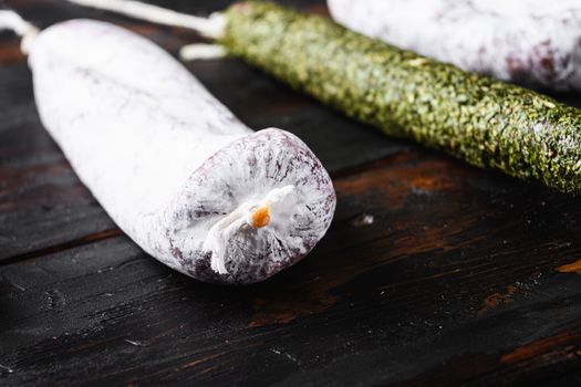 Spanish dry sausages on dark wood background.