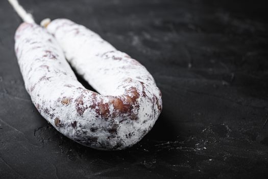 Fuet salami wurst on black background with space for text.