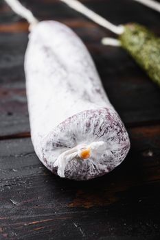 Spanish longaniza sausages on dark wood background.