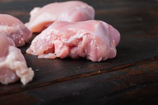 Organic chicken meat on dark wooden background with copy space.