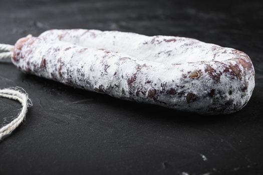 Fuet salami wurst on black background.