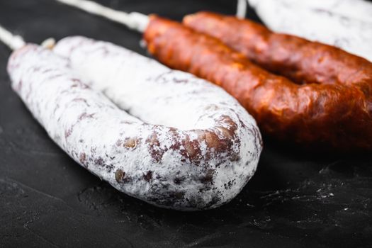 Traditional spanish sausages fuet and chorizo on black background.