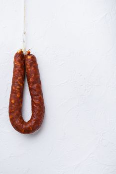 Spanish chorizo sausage on white textured background with copy space.