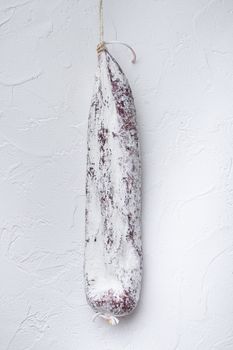 Longaniza spanish salami sausage on white textured background.