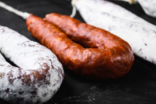 Traditional spanish sausages fuet and chorizo on black background.