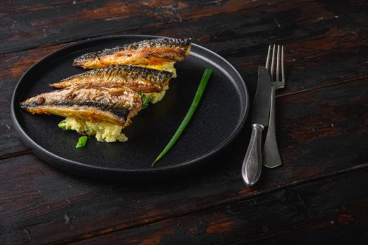 Amazing dish of marinated mackerel with garlic paprika and saffron.with softly mashed potatoes on dark wooden table.