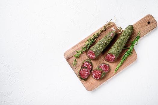 Sliced cuts of fuet salami sausage on white surface with copy space.