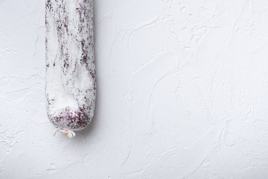 Longaniza spanish salami sausage on white textured background with copy space.