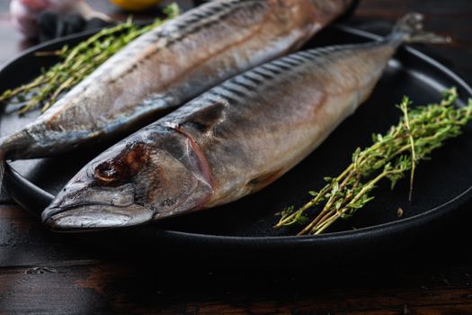 Fresh whole fish with ingredients on wooden table.