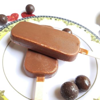 Delicious two chocolate icecream bar with chocolate ball in white plate plated beautifully