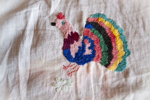 colorful peacock hand made embroidered smooth decoration on white fabric , vintage folk embroidery in Belarus, second half of 19 century