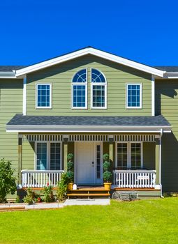 Entrance of residential house with door steps in front and blue sky background. British Columbia, Canada.