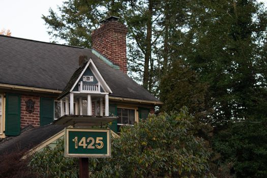 A Bird House That Looks Like a Real House on a Suburban Property