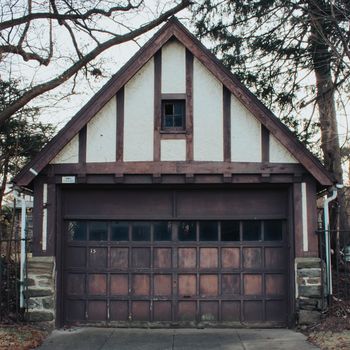 An Old-Fashioned Brown and White Garage on a Cloudy Day