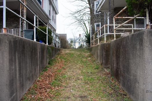 A Grass Hill Driveway Between Two Concrete Walls