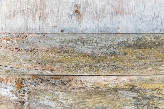 Wall of weathered wood boards with paint residues and damp