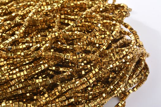 Beautiful gold Glass Sparkle Crystal Isoalted Beads on white background. Use for diy beaded jewelry. Space for text