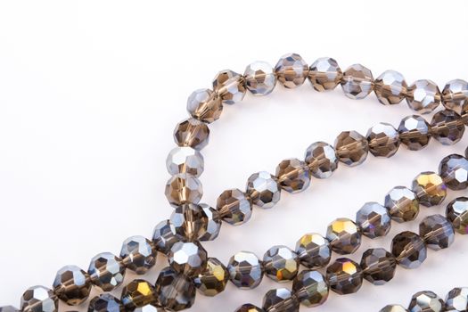 Beautiful gold beige brown Glass Sparkle Crystal Isoalted Beads on white background. Use for diy beaded jewelry. Space for text