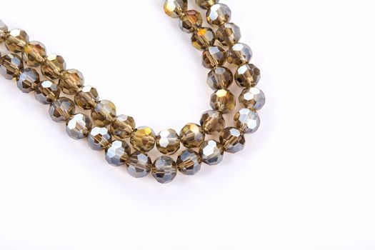 Beautiful gold beige brown Glass Sparkle Crystal Isoalted Beads on white background. Use for diy beaded jewelry. Space for text