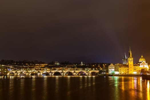 Panorama night view of the light illuminated Charles Bridge over Vltava River and the Bedrich Smetana Museum in the center of old town of Prague, Czech Republic