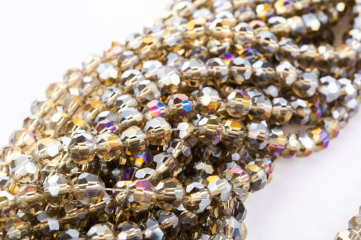 Beautiful gold beige brown Glass Sparkle Crystal Isoalted Beads on white background. Use for diy beaded jewelry. Space for text
