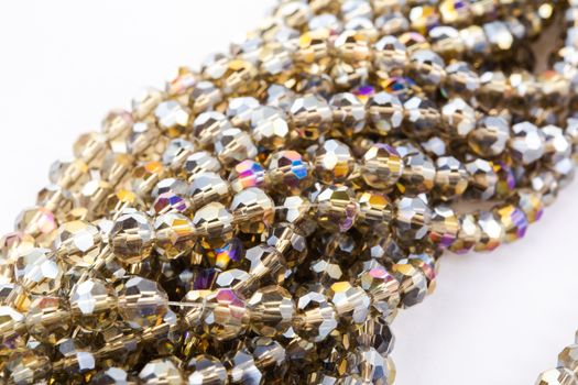 Beautiful gold beige brown Glass Sparkle Crystal Isoalted Beads on white background. Use for diy beaded jewelry. Space for text