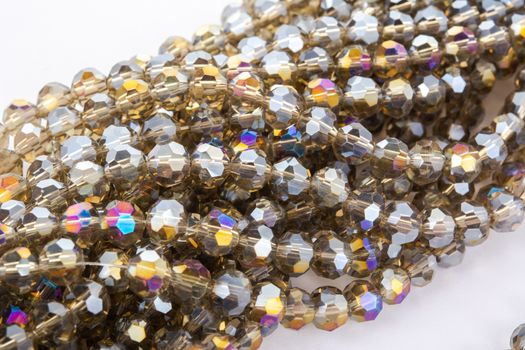 Beautiful gold beige brown Glass Sparkle Crystal Isoalted Beads on white background. Use for diy beaded jewelry. Space for text