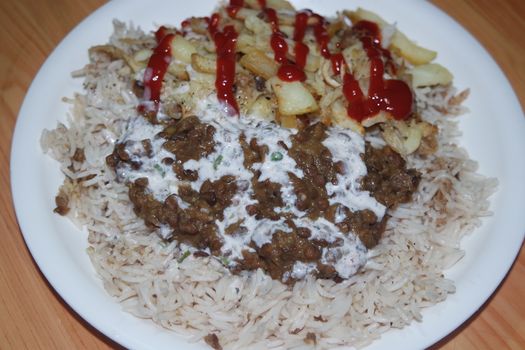 Delicious traditional dish of rice with potato fries and cereals with red ketchup. Food background with copy space for text and advertisements.