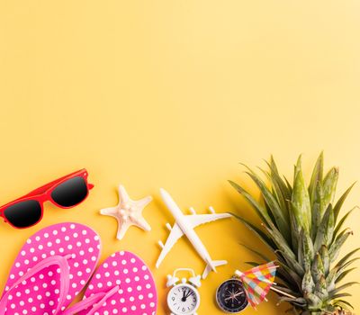 Celebrate Summer Pineapple Day Concept, Top view flat lay of funny pineapple, sunglasses, model plane, starfish and clock alarm isolated on yellow background, Holiday summertime in tropical