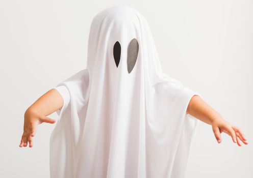 Funny Halloween Kid Concept, little cute child with white dressed costume halloween ghost scary, studio shot isolated on white background