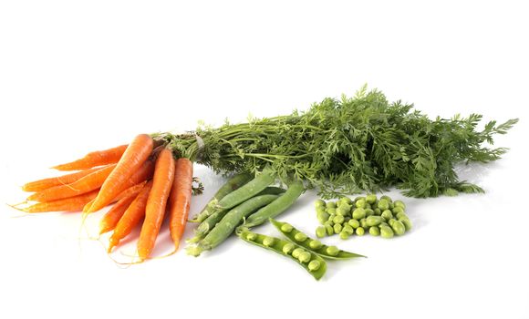 green peas and carrots in front of white background