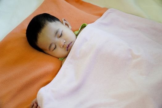 Close-up of a baby sleeping in bed.