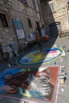 gubbio,italy august 29 2020:street artist and his works drawn on the ground