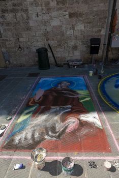 gubbio,italy august 29 2020:street artist and his works drawn on the ground
