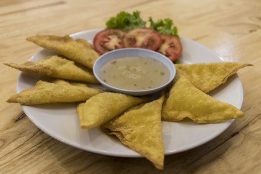 Thai food with cheese, sauce and salad. Snacks in Phuket. Tomatoes and greens.