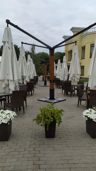 outdoor cafe prepared for the rain. Removed the chairs, rolled up the canopy