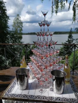 Champagne slide. Pyramid or fountain made of champagne glasses with cherry.