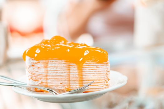 Closeup orange cake delicious on glass table background, selective focus