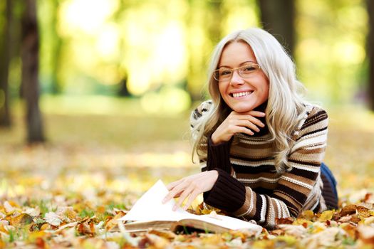 woman read the book in autumn park