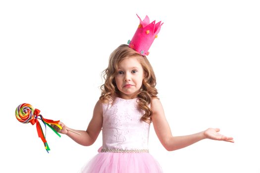 Beautiful little candy princess girl in crown holding big lollipop and posing with hands up in air saying, why, i dont know, so what