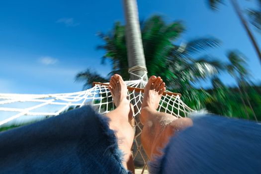Feets in a hammock on a summer tropical nature background vacation concept