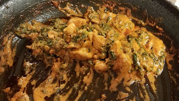 chicken and kale with sauce or gravy in skillet