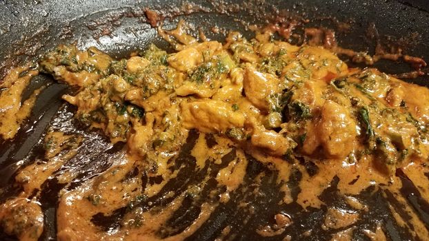 chicken and kale with sauce or gravy in skillet