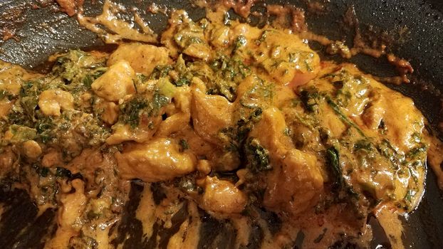 chicken and kale with sauce or gravy in skillet