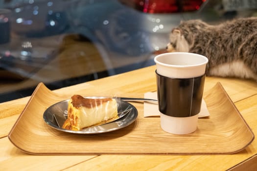 Cake and cup of coffee on wooden tray