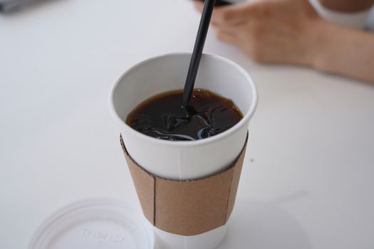 Pouring black coffee into cup