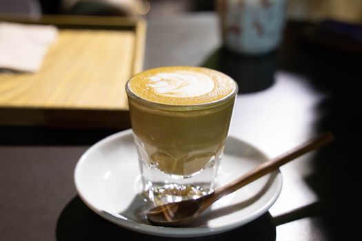 Spoon and cup of coffee on table