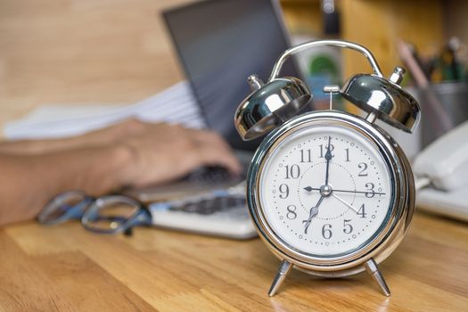clock on work desk  in the work office Time of working concepts office life on morning, selective focus the clock