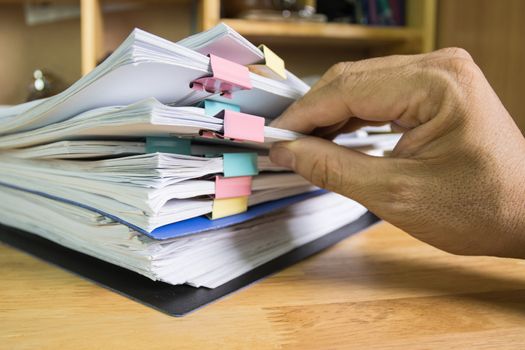 hand of man picked up the papers in the pile 